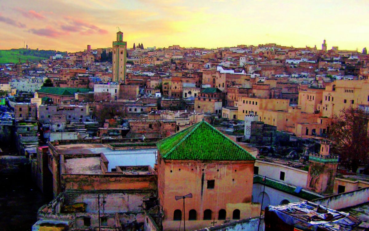 The warm glow of sunset bathes the historic cityscape of Marrakech, a sight to behold for travelers.