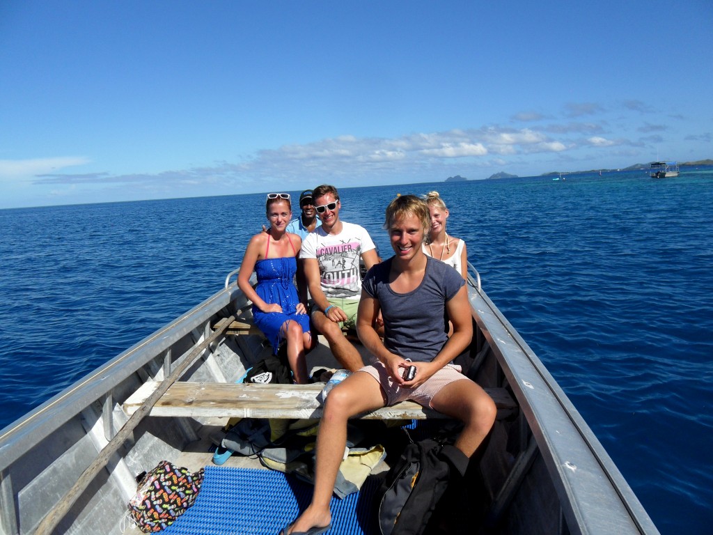 A group of tourists siting in a Fijian boat while taking a boat tour, one of the many things to do in Fiji