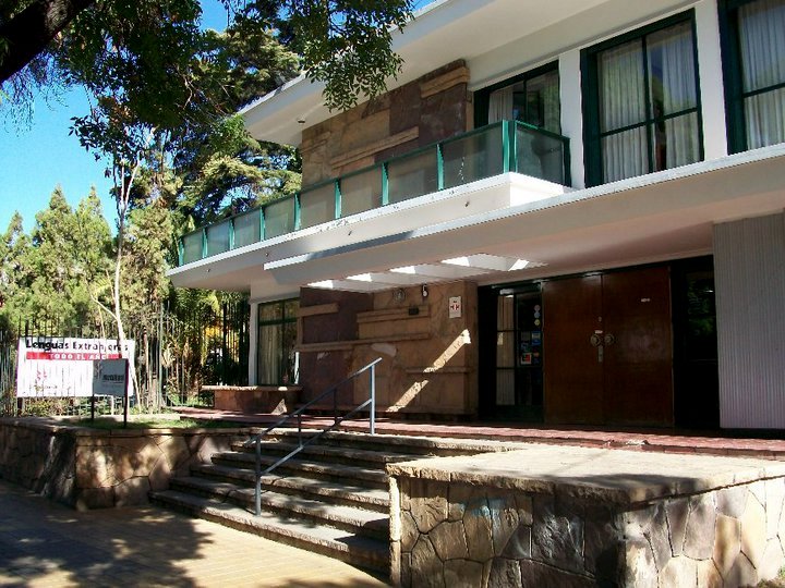 Entrance to a modern language school with a sign promoting extra classes, ideal for quick Spanish learning.
