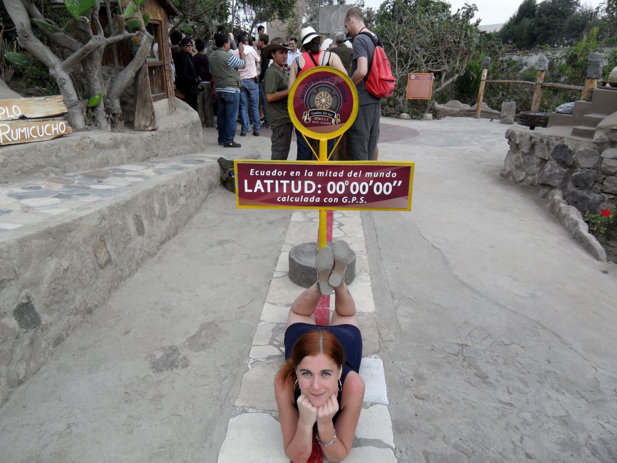 Woman lying on the equatorial line at the Mitad del Mundo, a poplar thing to do in Quito, Ecuador