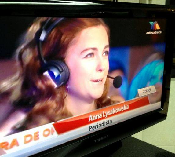 Smiling Anna with headphones appearing on a Spanish talk show, engaging in fast language practice.