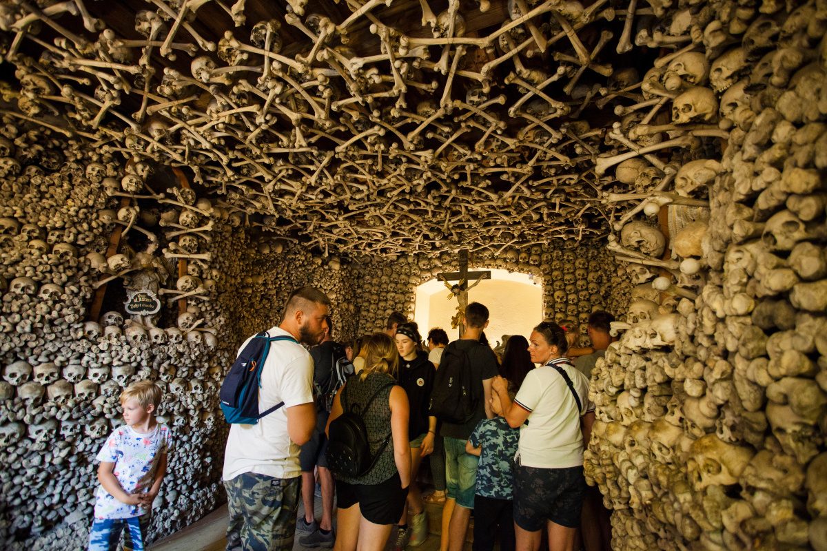 Chapel of Skulls Visitors exploring the haunting yet historically significant interiors of the Kaplica Czaszek, the Chapel of Skulls in Poland, lined with bones and skulls.
