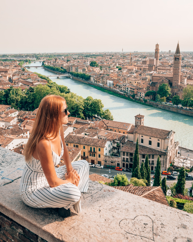 Sitting by the riverside enjoying the picturesque views of Verona's historic center, a peaceful thing to do while visiting.