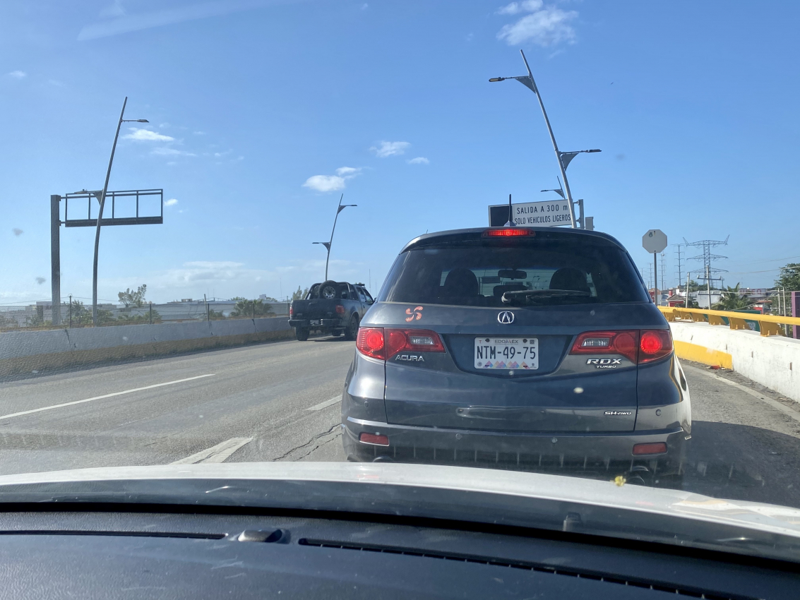 Traffic scene on a Mexican road, a common sight when renting a car and traveling through busy areas.
