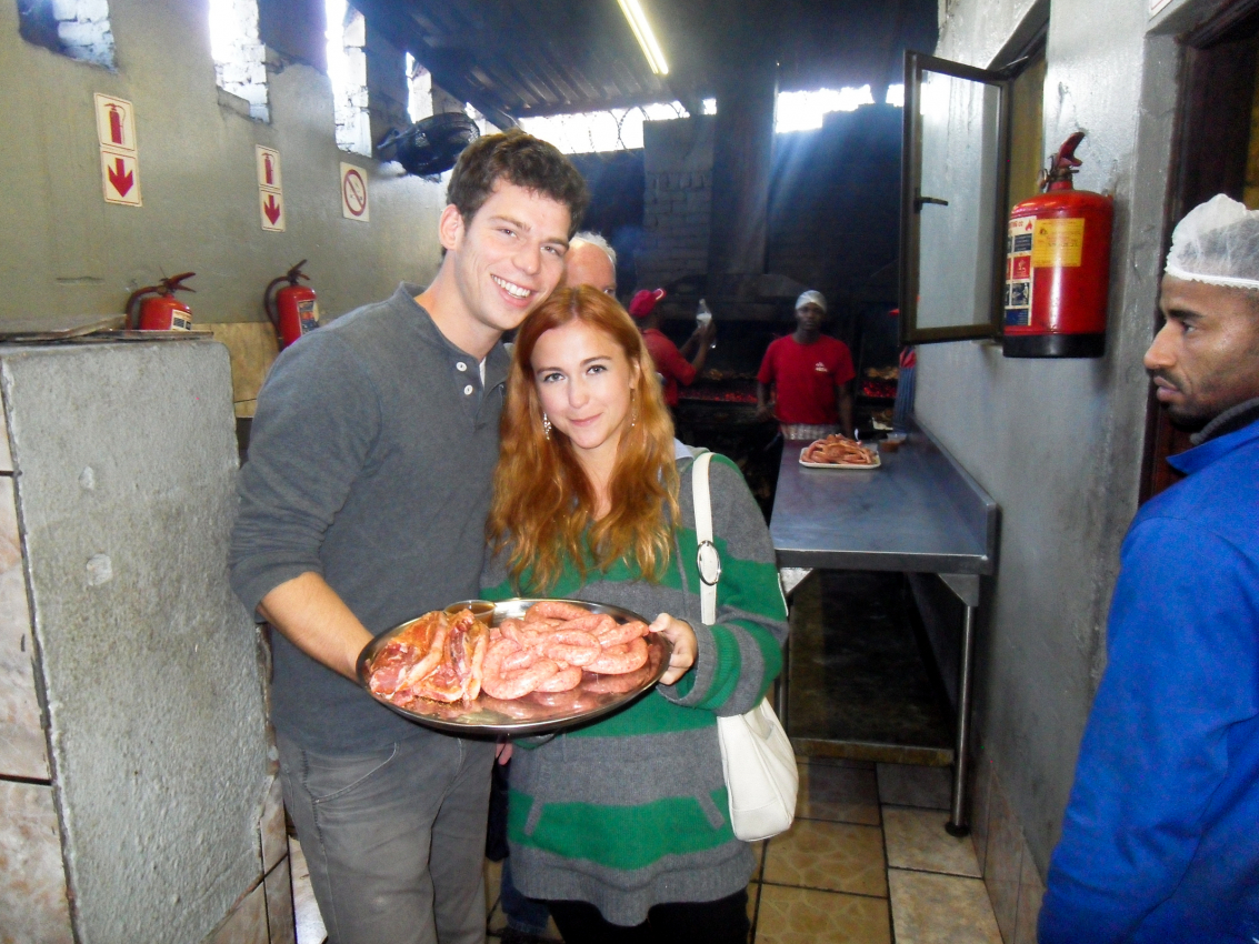 Couple enjoying authentic South African cuisine at a traditional braai in Cape Town, showcasing the city's rich culinary scene away from the typical tourist trail.