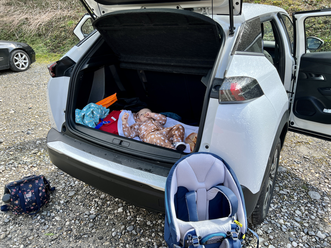 Changing diaper in the trunk of an car during road trip, portraying the impromptu nap times when traveling in France with a baby.
