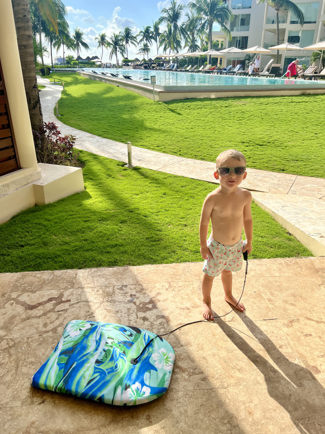 Little boy with sunglasses, excited for a pool day at a Mexican resort, complete with a baby-friendly float.